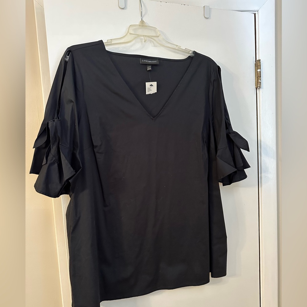 Black top with cold shoulder and bow details on the sleeves.